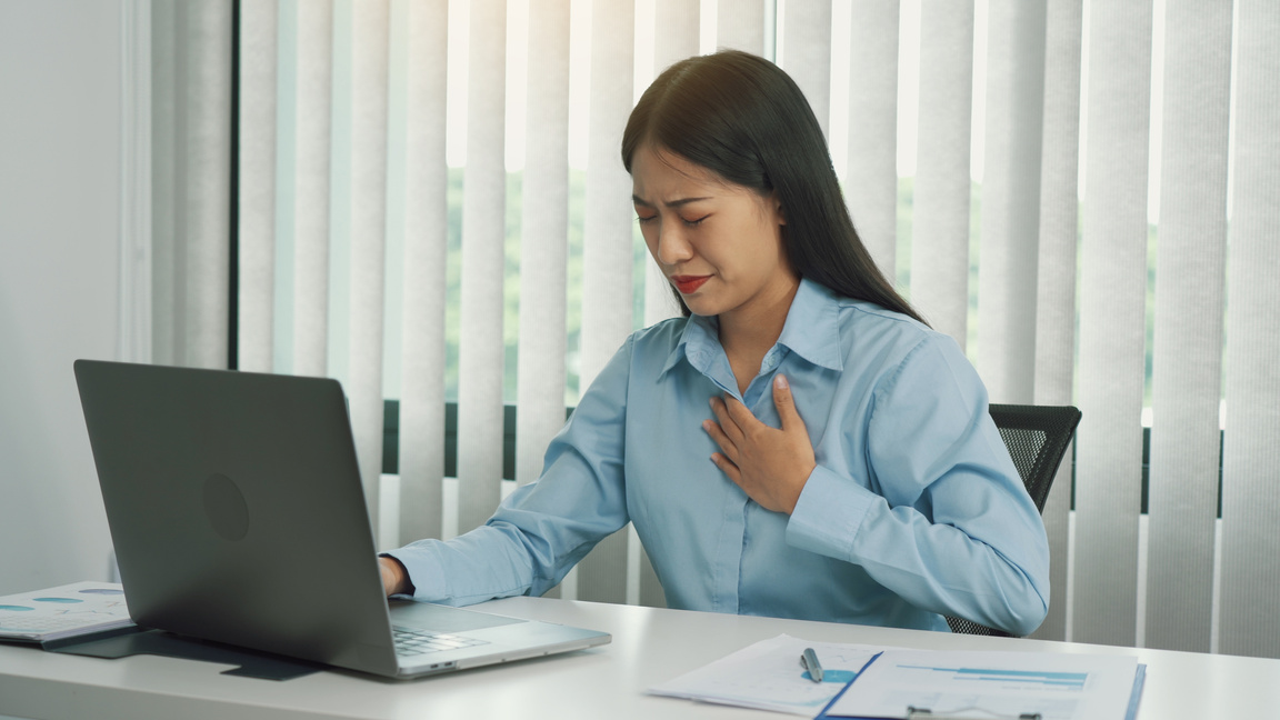 Woman with Chest Pain Working in the Office